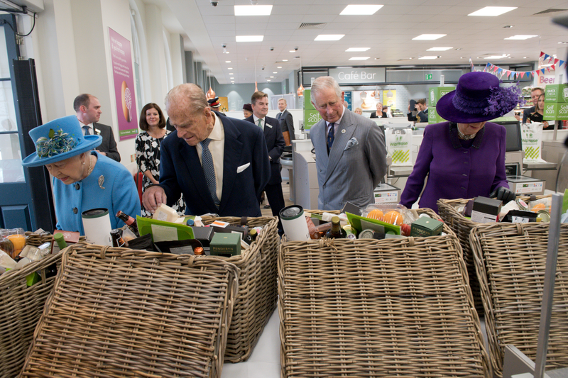 Britain’s Queen Elizabeth II, Prince Philip, Duke of Edinburgh, Prince Charles, Prince of Wales and Camilla, Duchess of Cornwall look at food hampers during a visit to a Waitrose supermarket in the town on October 27, 2016 in Poundbury, England. Photo via Getty Images.